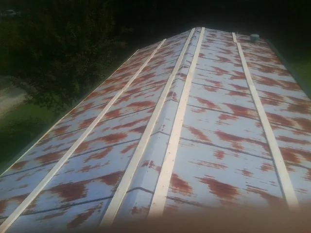 Rusted metal roof panels with new wood purlins before replacement — Storm Damage Roof Repair in Fayville by Roofing Brothers