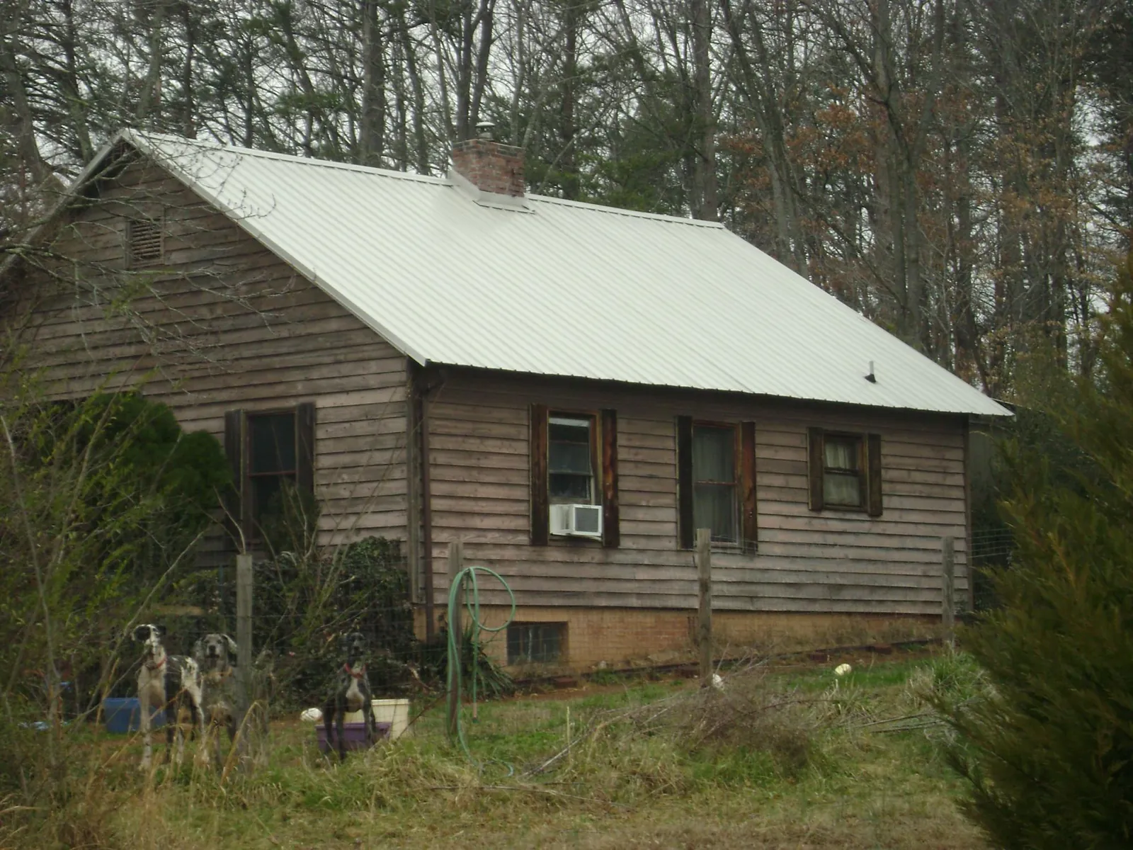White metal roof on an old wood sided farmhouse, from a Metal Roof Installation job in Fayville